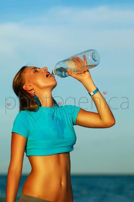 Woman drinking water after jogging