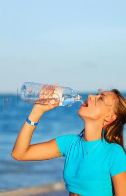 Woman drinking water after jogging